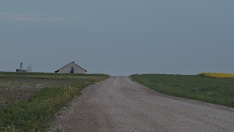 Tranquil-scene-with-a-road-and-a-farmhouse-in-Poland,-static-wide-shot