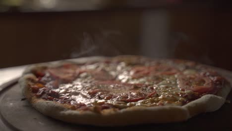 Close-up-of-Delicious-smokey-home-made-pizza-on-a-wooden-plank-Slow-Motion-60FPS