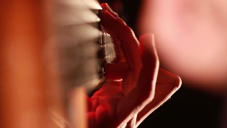 blurred-hands-playing-a-classical-guitar-closeup-macro-with-black-dark-background