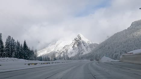 POV-Eines-Fahrers,-Der-Im-Winter-Auf-Der-Verschneiten-Straße-Des-Snoqualmie-Passes-In-Cascade-Range,-Washington,-USA,-Fährt