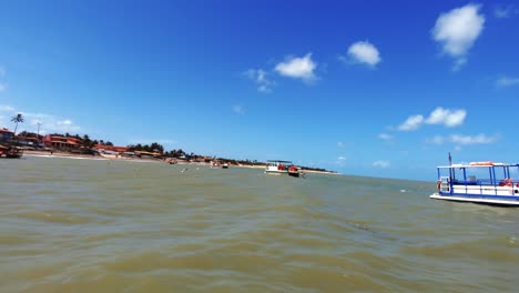 Various-tour-boats-docked-along-the-coast-of-the-tropical-Maracajau-in-Rio-Grande-do-Norte,-Brazil-on-a-warm-bright-sunny-summer-day