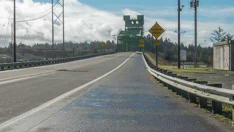 Many-Vehicles-Traveling-On-Bullards-Vertical-lift-Bridge-Against-Cloudy-Sky-In-Bandon,-Oregon-USA