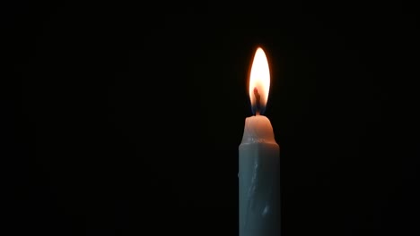 burnt-white-candle-in-a-dark-room