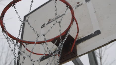 Basketballplatz-Nahaufnahme-Des-Basketballkorbs,-Der-Sich-Auf-Dem-Eisennetz-Bewegt