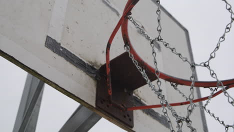 Handheld-closeup-of-worn-down-basketball-hoop-at-urban-basketball-court