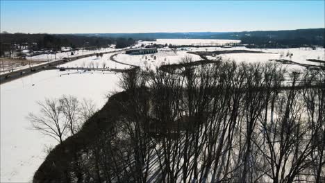 Flying-over-trees-toward-a-frozen-fishing-pond-in-Clarksville,-Tennessee