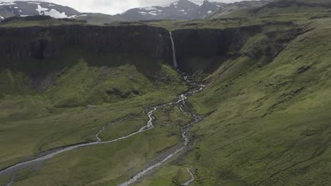 Flying-towards-Grundarfoss-waterfall,-tourist-attraction-in-Iceland-landscape