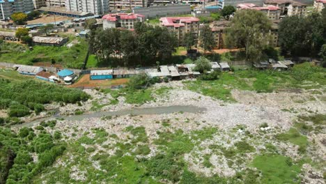 Drone-Inspeccionando-La-Presa-Cubierta-Por-Jacinto-De-Agua-En-Nairobi-Kenia,-Asentamiento-De-Casas-En-La-Presa-De-Nairobi,-Vista-Panorámica-Del-Drone-Volando-En-La-Presa-De-Nairobi