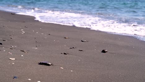 Slow-moving-waves-pushing-around-small-pebbles-on-beach