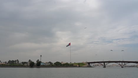 Flag-of-the-United-Arab-Emirates-waving-in-the-air-at-Sharjah's-Flag-Island-on-a-cloudy-winter-day