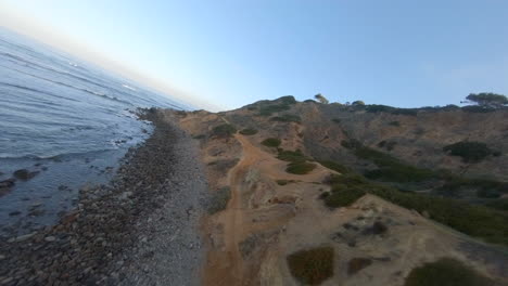 Flying-along-a-cliff-overlooking-the-ocean-in-a-racing-first-person-view-drone