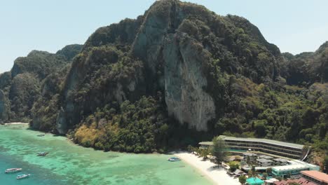 Towering-limestone-cliff-restraining-Tonsai-Bay-in-Ko-Phi-Phi-Don-Island,-Thailand---Aerial-Fly-over-shot