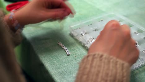 Closeup-Shot-Of-Bracelet-Jewellery-Making,-Craft-Using-White-Alphabet-Beads