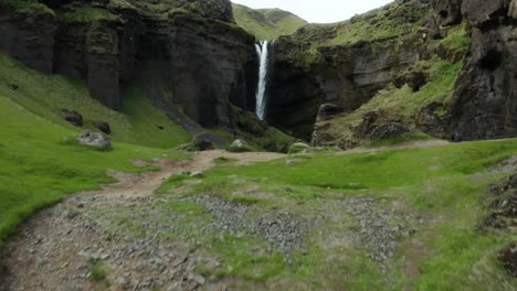 Steigt-Vom-Grünen-Hang-Auf,-Um-Den-Atemberaubenden-Kvernufoss-Wasserfall-In-Der-Island-Schlucht-Zu-Enthüllen