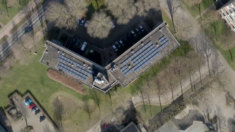 Top-down-aerial-of-solar-panels-on-large-apartment-building-rooftop