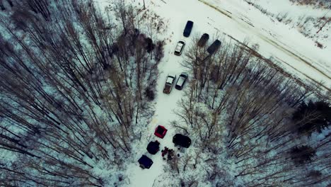 aerial-birds-eye-view-winter-drop-decline-over-people-dogs-camping-in-the-cold-just-steps-from-their-cars-trucks-vans-parked-off-a-backroad-of-crown-land-in-Canada's-Matthews-Crossing-free-of-charge