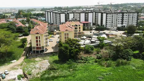 Real-estate-of-the-nairobi-estate-located-near-dam-of-Nairobi,-drone-flying-away-from-the-estate-of-dam-nairobi,-modern-houses-of-nairobi-kenya