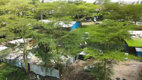 Drone-flying-from-the-village-in-the-dam-estate-of-Nairobi-kenya,-Acacia-trees-in-the-village-of-nairobi