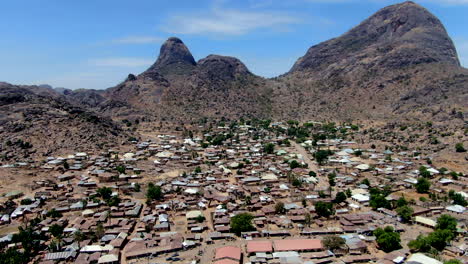 The-Nigerian-city-of-Dass-beneath-the-rugged-mountains-of-the-Bauchi-State---push-forward-aerial-view