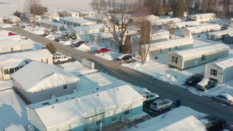 Aerial-of-prefabricated-mobile-home,-trailer-park-covered-in-winter-snow-in-rural-USA,-Appalachia
