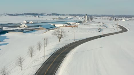 Car-on-curvy-road-through-winter-snow-landscape
