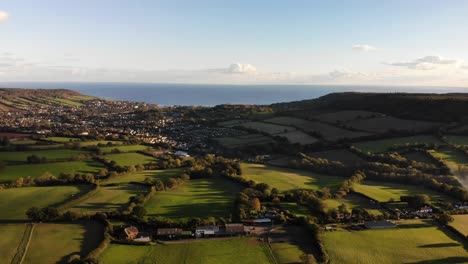 Aerial-View-panning-right-from-Firebeacon-Hill-looking-towards-Sidmouth-and-Lyme-Bay-England-UK