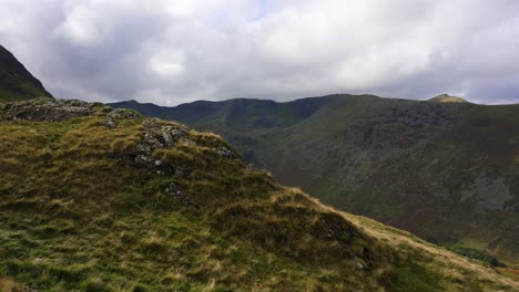 Slow-panning-shot-toward-the-distant-ridge-of-Striding-Edge-from-the-slope-of-St-Sunday-Crag-in-the-UK-Lake-District-on-an-overcast-day