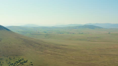 Aerial-shot-over-a-vast-open-plain-with-hills-in-the-distance