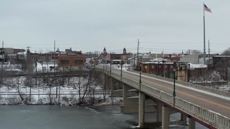 Ascend-and-fly-over-main-road-and-bridge-of-small-American-town