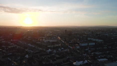 4K-aerial-view-of-taunton-Somerset,-United-Kingdom-in-the-sunset,-drone-moving-back-and-showing-the-blue-sky-with-some-clouds