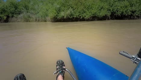 POV-shot-of-a-woman-with-tattooed-arms-rowing-turning-an-inflatable-catamaran-around-in-the-Gunnison-River