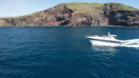 Speedboat-travels-on-blue-Atlantic-Ocean-with-Ilhéu-da-Cevada-in-background