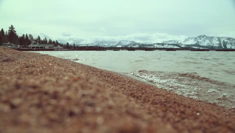 Sandy-Lake-Tahoe-beach-surrounded-by-the-Sierra-Nevada-Mountains-covered-in-snow-landscape-and-dramatic-clouds-and-light