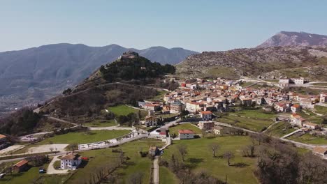 Aerial-landscape-view-of-Pietraroja,-an-italian-village-on-a-hill-top,-on-a-sunny-day