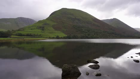 Panning-view-over-Brothers-Water,-a-small-lake-in-the-English-Lake-District-on-a-quiet-and-peaceful-overcast-day