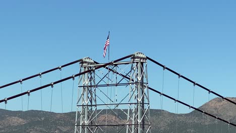 Bandera-De-Estados-Unidos-En-La-Torre-De-Suspensión-Que-Sostiene-El-Puente-Sobre-Royal-Gorge,-Colorado
