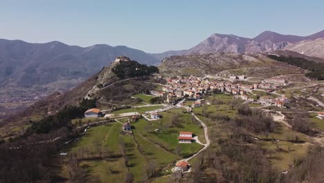 Aerial-panoramic-landscape-view-of-Pietraroja,-a-hill-top-village-in-Italy,-on-a-bright-sunny-day