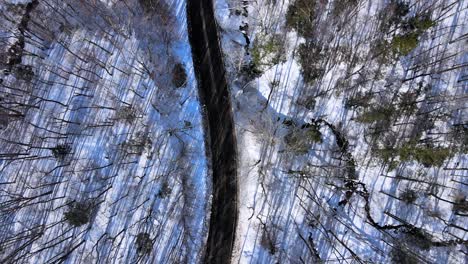 Aerial-drone-top-down-footage-of-a-country-road-through-the-snowy-mountains