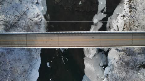 Top-down-descending-view-of-asphalt-road-bridge-during-cold-winter