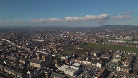 4K-aerial-view-of-taunton-Somerset,-United-Kingdom,-drone-moving-forward-and-showing-the-blue-sky-with-some-clouds
