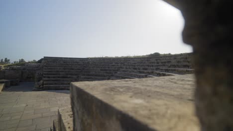 Slow-motion-reveal-of-an-old-Roman-Odeon-theatre-with-the-sun-beaming-over-the-stone-seating