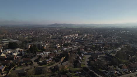 4K-aerial-panoramic-view-of-taunton-Somerset,-United-Kingdom,-drone-moving-to-the-right-showing-the-blue-sky-and-the-mountains-in-the-background
