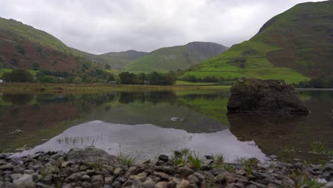 Low-slider-shot-of-placid-Brothers-Water-lake-on-an-overcast-day,-Lake-District,-Cumbria,-England