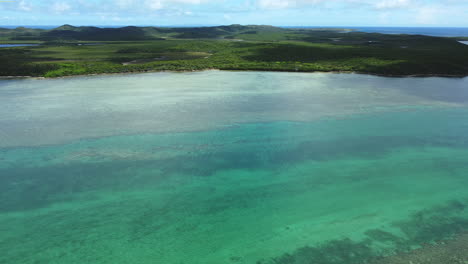 Wide-aerial-flyover-looking-down-on-Boat-Pass,-northern-point-of-New-Caledonia