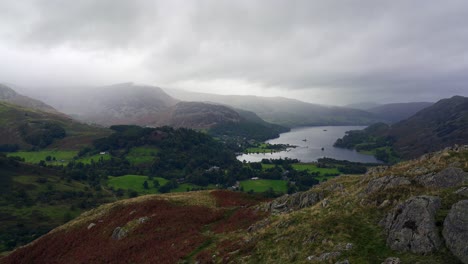 Epic-moody-clouds-partially-obscure-the-fells-of-the-Lake-District-overlooking-Ullswater-lake-on-a-rain-soaked-day