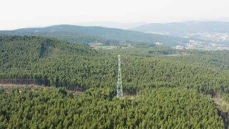 Strommast-Inmitten-Eines-Riesigen-Portugiesischen-Bergwaldes---Langsame-Luftaufnahme-Aus-Der-Umlaufbahn