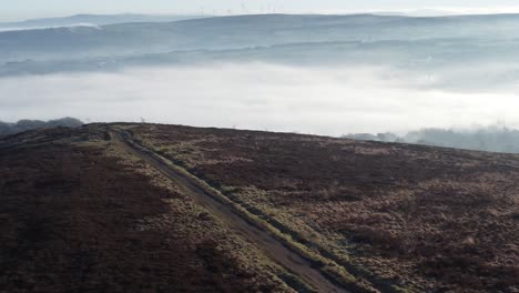 Cloudy-misty-sunrise-valley-aerial-moorland-hiking-hillside-rural-pathway-Lancashire-pull-back