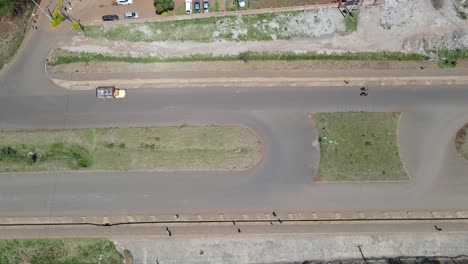 Aerial-view-above-a-highway-road,-with-vehicles-speeding-by,-in-Nairobi,-Kenya