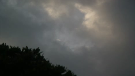Zeitraffer,-Dunkle-Wolken-Am-Himmel-Mit-Gewitterbäumen-Im-Vordergrund