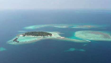 Asombrosa-Vista-Aérea-De-Las-Islas-Maldivas-Con-Un-Bote,-Agua-Turquesa,-Palmeras-Y-Arena-Blanca